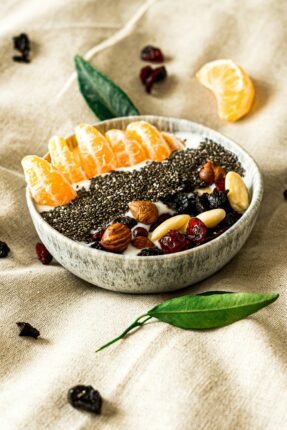 a bowl filled with fruit and nuts on top of a table